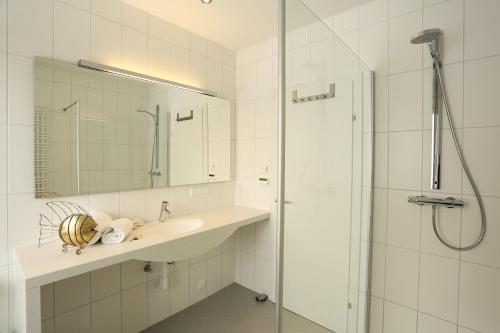 沃尔特湖畔韦尔登西维伦精益酒店的白色的浴室设有水槽和淋浴。