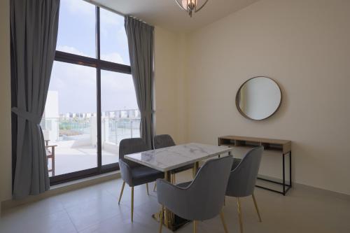 迪拜Fabulous 4br villa with Balcony的一间带桌椅和镜子的用餐室