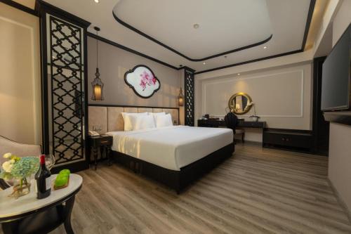 河内FTE Ba Dinh Hotel的一间酒店客房,配有一张床和一台电视