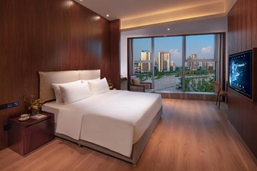 重庆寻光酒店(重庆两江幸福广场店)的卧室设有一张白色大床和大窗户
