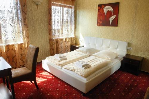 弗里森海姆克朗酒店的卧室配有一张白色大床和一把椅子
