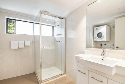 拜伦湾卡普公寓的带淋浴、盥洗盆和镜子的浴室