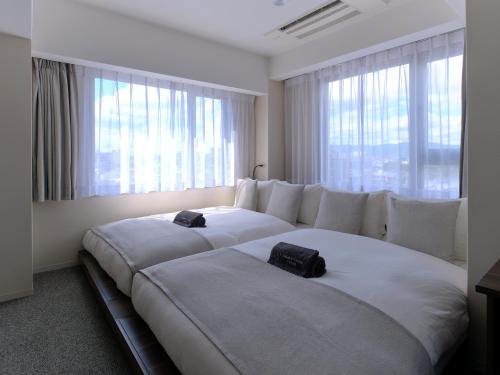 京都Sakura Cross Hotel Kyoto Kiyomizu的卧室设有2张大床,位于窗户前