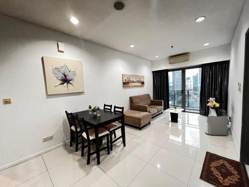 吉隆坡Summer Suites KLCC By Homestay的客厅配有桌子和沙发