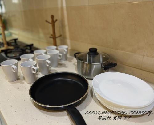 大山脚2 Storey House Bayu Mutiara @ Bukit Mertajam的配有煎锅和白杯的台面