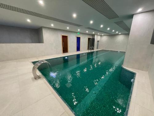 埃尔比勒达林酒店的一座绿色的游泳池,位于一座建筑中
