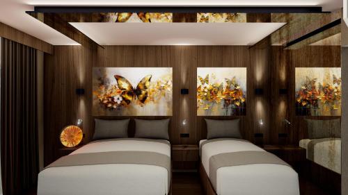 库萨达斯duqqan deluxe hotel的墙上画作的房间里设有两张床
