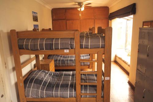 利马Inkawasi Miraflores Hostel的一间房间,设有三张双层床