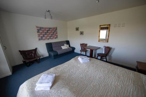 BreiðavíkHotel Breidavik的一间卧室配有一张床、一张沙发和一张桌子