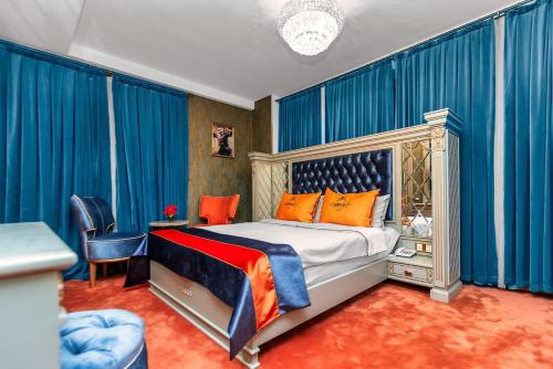 巴库Manor Luxury Hotel Baku的一间卧室配有一张蓝色窗帘的床
