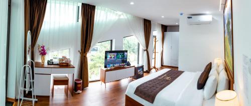 老街市Big Hotel Lào Cai的一间卧室配有一张床、一张书桌和一台电视
