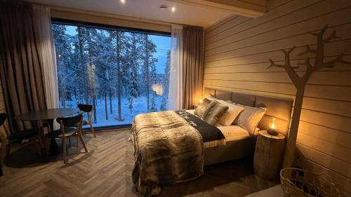 罗瓦涅米Invisible Forest Lodge的一间卧室配有一张床、一张桌子和一个窗户。