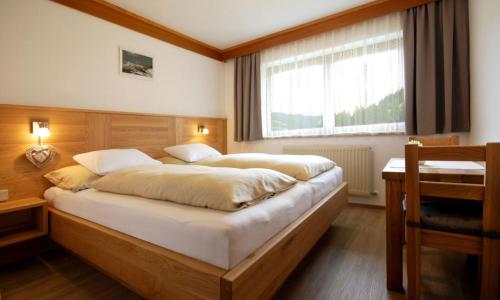 萨尔巴赫Appartementhaus Daniel的一间卧室设有一张大床和一个窗户。