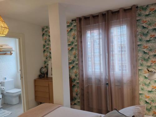 桑坦德Apartamento Casa Palabra的卧室设有滑动玻璃门和卫生间