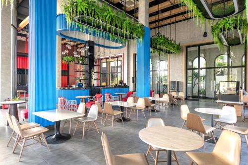 潘切K-Town Resort Phan Thiet的一间设有桌椅的餐厅,种植了植物