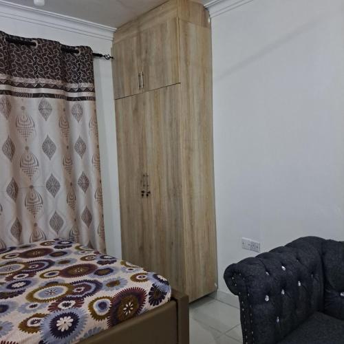 NdomeDolphin-holiday homes mombasa的卧室配有木制橱柜,位于床边