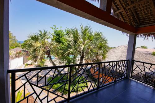马哈赞加Le jardin des délices的阳台种有棕榈树,享有海滩美景