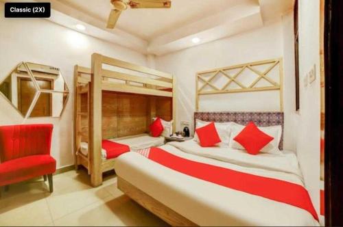 新德里OYO Flagship Hotel BalaG的一间卧室配有两张床和红色椅子