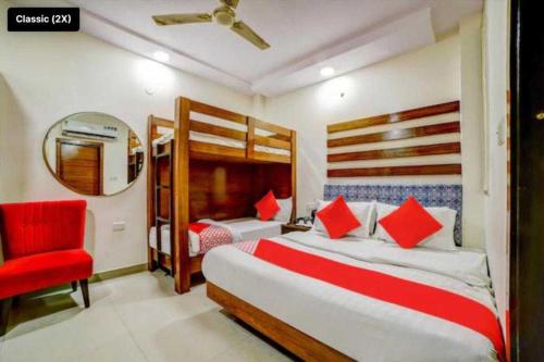 新德里OYO Flagship Hotel BalaG的一间卧室配有两张床和红色椅子