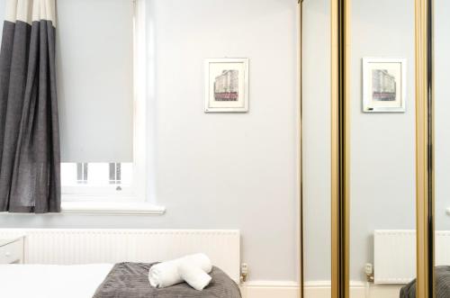 伦敦Oxford Circus Central Apartments的卧室设有白色墙壁和金色镜子