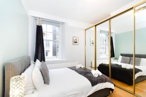 伦敦Oxford Circus Central Apartments的一间卧室配有一张床和镜子