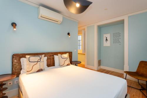 里斯本卡萨斯·拜萨 - 朱丽思和马德琳酒店的一间卧室配有一张带白色床单的大床