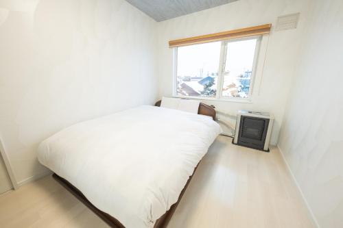 富良野furano ski rabi的一间小卧室,配有床和窗户