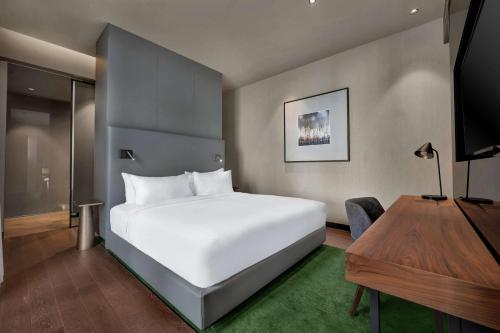 加亚新城Hilton Porto Gaia的卧室配有一张白色大床和一张书桌