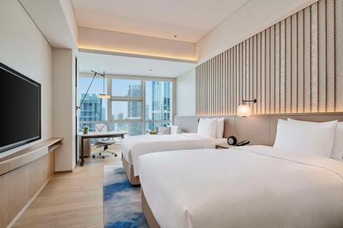 珠海珠海横琴希尔顿逸林酒店的酒店客房设有两张床和一台平面电视。