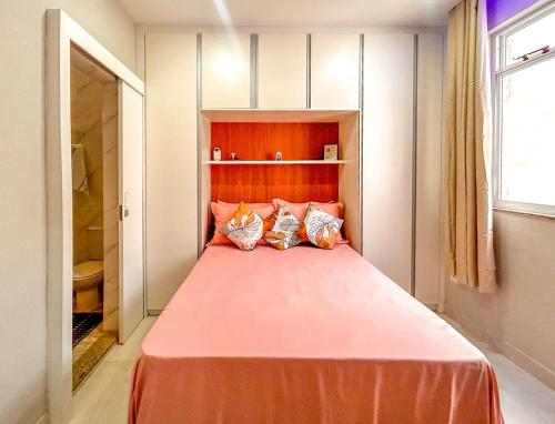 里约热内卢Ótimo studio c WiFi a 190m da Praia do Leme - RJ的卧室配有带3个枕头的大型粉红色床