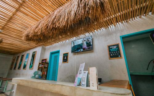 爱妮岛Mad Monkey Hostel Nacpan Beach的一间墙上有柜台和标志的餐厅