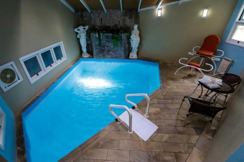 格拉玛多阿维尼达汽车旅馆（仅限成人入住）的游泳池,四周摆放着椅子