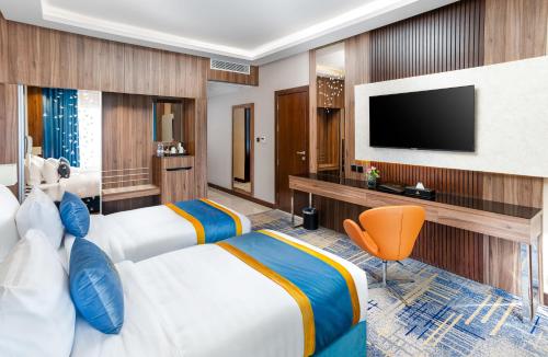 麦地那ايليت الخالدية的酒店客房设有两张床和一台平面电视。