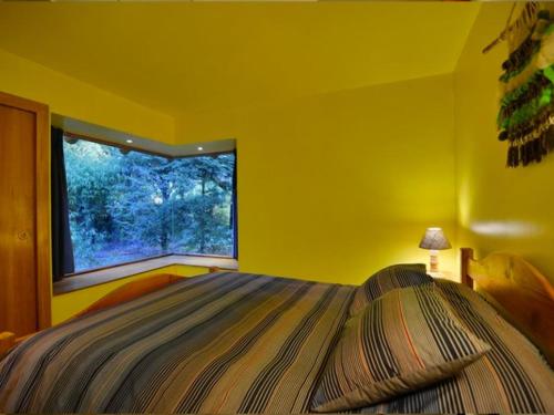 普孔埃尔托斯戴尔拉戈山林小屋的黄色的卧室设有床和窗户