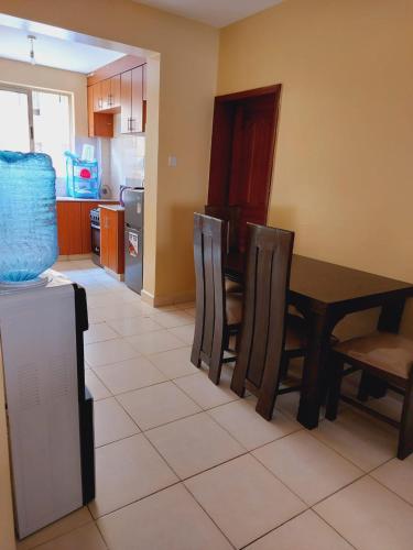 内罗毕Solomon's Palace - Nairobi的厨房以及带桌椅的用餐室。