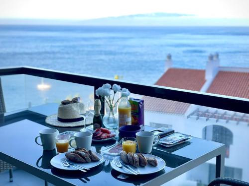 圣地亚哥港Bahia de Santiago的阳台上的餐桌和食物,享有海景