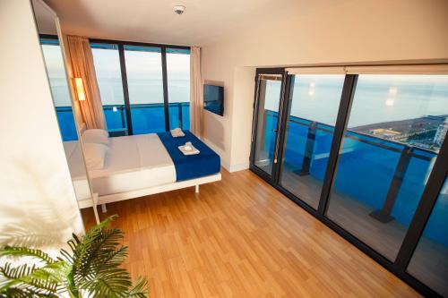 巴统Panorama Orbi Resort的客房设有一张床和大窗户