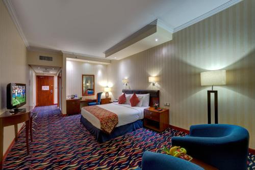 迪拜MD Hotel By Gewan的一间酒店客房,配有一张床和一台电视