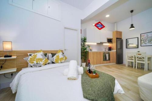 马德里(J1) Ubicado en Madrid Centro - 5 personas.的一间带白色大床的卧室和一间厨房