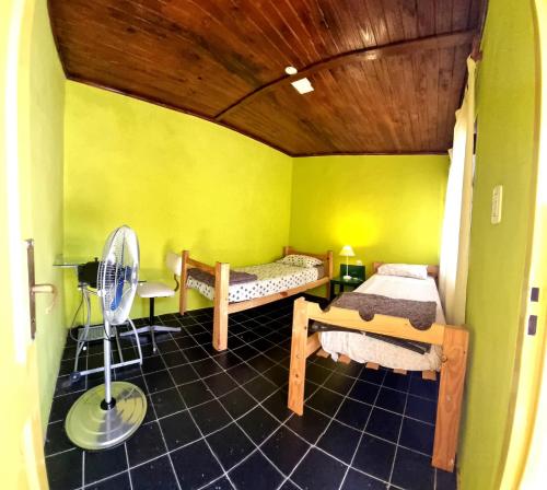 乌拉圭河畔康塞普西翁Hostal - Sueños del Rio的小房间设有两张床和风扇