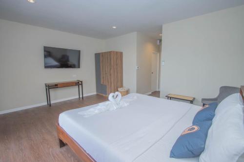 芭东海滩RoomQuest The Peak Patong Hill的卧室配有带蓝色枕头的大型白色床