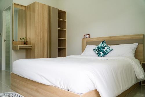 Ban Dam Phraเมตตา เรสซิเด้นซ์ - Metta Residence的卧室配有一张白色大床和木制床头板