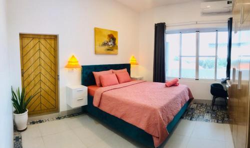 Ấp Thiện SơnCasa Vi Mia的一间卧室配有带粉红色枕头的床和窗户。