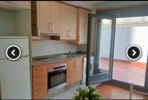 波伊奥Apartamento en Pontevedra con terraza y garaje的厨房配有木制橱柜和滑动玻璃门