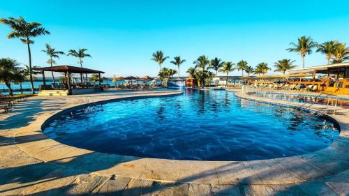 巴西利亚MODERNO FLAT LAKE SIDE的度假村内一座种有棕榈树的大型游泳池