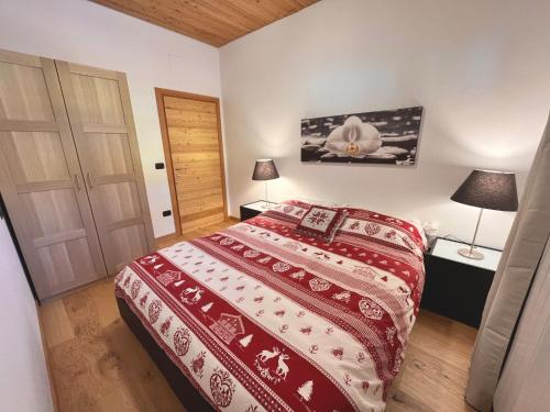 泰穆Chalet Bel-Air A due passi dalle piste, con giardino e posto auto的一间卧室配有一张带红色和白色床罩的床。