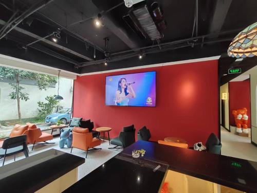 苏州不负韶华青年旅馆的一间客厅,在红色的墙上配有电视