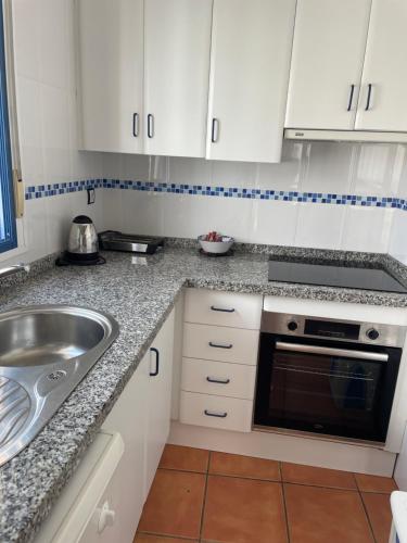 拉斯内格拉斯La Rosada 9的厨房配有白色橱柜和水槽