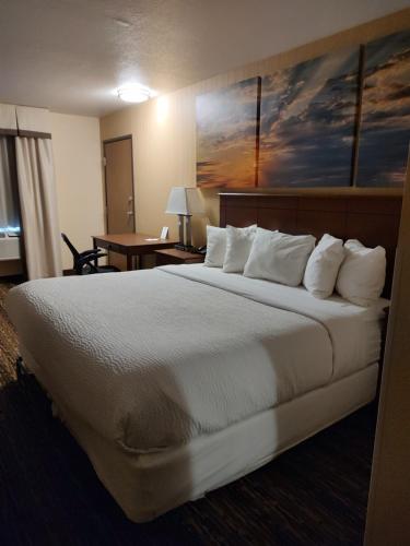 法戈法戈机场戴斯汽车旅馆及套房的酒店客房配有一张带白色枕头的大床