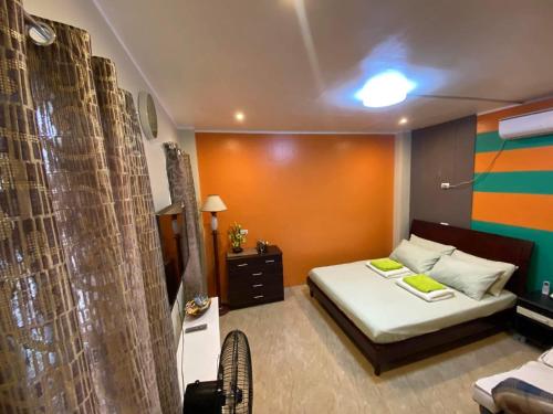 宿务Peach Haven的一间小卧室,配有床和橙色墙壁